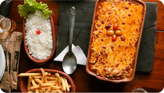 Imagem vista de cima de uma parmegiana, arroz e batata frita